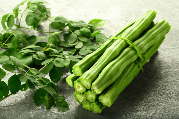 Healthy vegetable- moringa fruit and leaves on vintage background